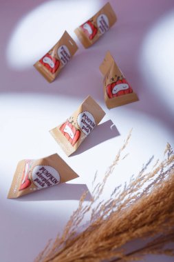 İzmail, Ukrayna. Mayıs 2022. Gece maskeli balkabağı uyku tulumları beyaz masada, sert gölgelerde küçük paketlerde. bakım kozmetikleri