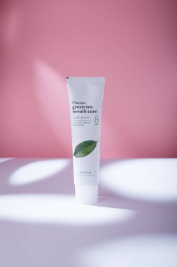 İzmail, Ukrayna. Mayıs 2022. Median Pleasia yeşil çay nefesi diş macunu doğal taze, beyaz masaya tüp, sert ışıkta pembe zemin