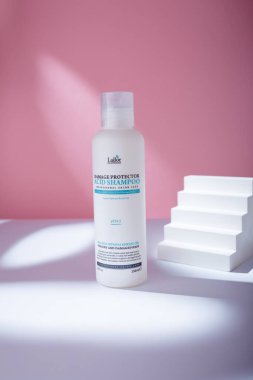 Izmail, Ukraine. May 2022. Lador Damage protector Acid Shampoo white bottle on pink background. Korean hair care cosmetics