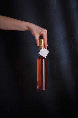 Üzerinde şablon etiketi olan pembe şarap şişesi, markasız. Riesling, chardonnay, sauvignon blanc. Siyah arkaplanda alkol içeceği