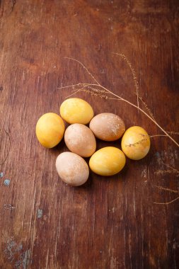 Paskalya kutlaması için zerdeçal ve biberle boyanmış sarı ve kahverengi DIY yumurtaları. Üst görünüm, kopyalama alanı, dikey çekim