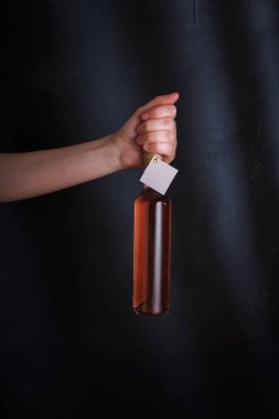 Üzerinde şablon etiketi olan pembe şarap şişesi, markasız. Riesling, chardonnay, sauvignon blanc. Siyah arkaplanda alkol içeceği