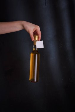 Üzerinde şablon etiketi olan beyaz şarap şişesi, markasız. Riesling, chardonnay, sauvignon blanc. Siyah arkaplanda alkol içeceği