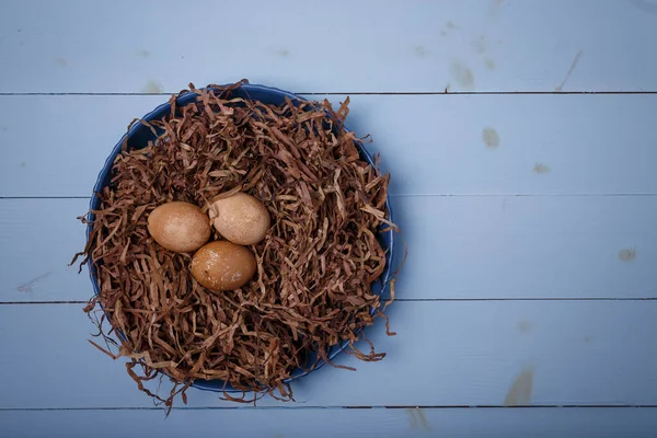 Telur Paskah Sarang Coklat Dekoratif Dengan Latar Belakang Kayu Biru — Stok Foto