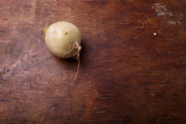 Taze karpuz turpu, beyaz derili daikon kökü sebzesi ve kahverengi ahşap arka planda mor. Üst görünüm, alanı kopyala