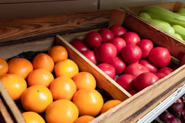 Market rafındaki ahşap kutularda olgun sarı ve mikado domatesler. Yerel tarım, mevsimlik organik sebzeler..