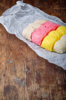 Multicolored pismaniye or pishmaniye also known as cotton candy, dragons beard or candy floss. Light halva, traditional turkish sweets. Dessert on paper, wooden background clipart