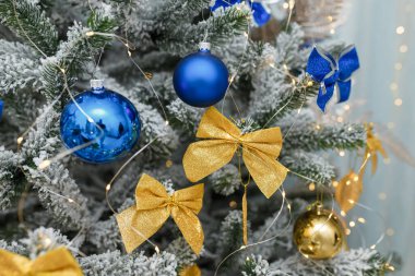 Güzel Ukrayna Noel ağacı, mavi ve sarı fiyonklu, ampullü. Yakın çekim..