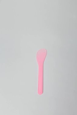 Balmumu depilasyonu ya da beyaz arka planda şekerleme için pembe plastik tek kullanımlık kozmetik spatula. Güzellik prosedürleri, cilt bakımı. Boşluğu kopyala.