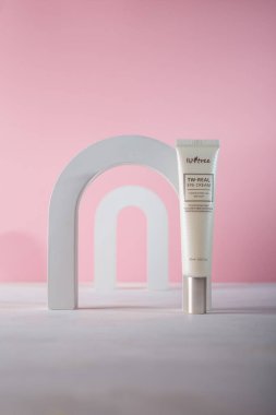 İzmail, Ukrayna. Temmuz 2024. Pembe arka planda, beton dekoratif elementlerle Kore kozmetik tüpü. ISNTREE tonu ve kırışık göz kremi.