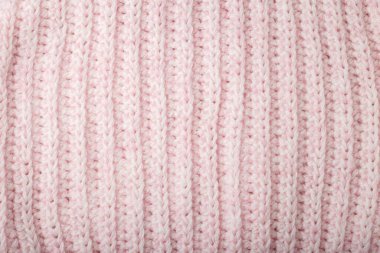 Açık pembe yün örgü desenli örgü, örülmüş arka plan. Soyut süveter yüzeyi, örülmüş iplik.