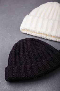 İki örülmüş yün bere ya da şapka, ahşap arka planda siyah beyaz