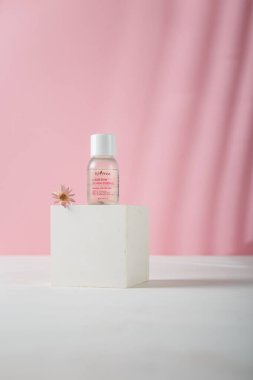 İzmail, Ukrayna. 16 Ağustos 2024. Bir şişe Isntree temiz cilt esansı beton tezgahta, pembe arka plan. Ürün reklam afişi, kopyalama alanı.