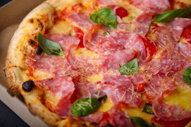 Pizza yakın çekim dokusu, yemek kalıbı geçmişi. Jambon, domates, yeşil fesleğen yaprağı ve peynir..