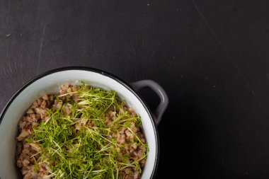 Taze tere salatası mikroyeşiliyle süslenmiş bir kase karabuğday. Su teresi tabağa son dokunuş olarak vurur. Vegan, vejetaryen organik sağlıklı yiyecekler.