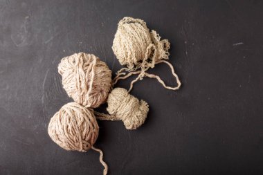 Siyah arka planda bej iplik topları, kopyalama alanı. Örgü ve tığ işi..