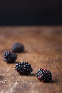 Kahverengi ahşap masa zemininde taze böğürtlen, yakın plan çekim, kopyalama alanı.