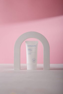 İzmail, Ukrayna. Temmuz 2024. Botanite Aqua uygun güneş esansı SPF 50. Pembe arka planda Kore kozmetik tüpü. Ürün reklam afişi, kopyalama alanı. Beton kemer dekoru