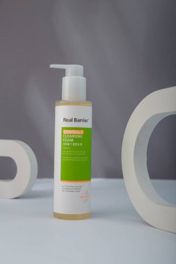 İzmail, Ukrayna. Temmuz 2024. Gerçek bariyer kontrol T temizlik köpüğü şişesi. Kore kozmetik ürünleri, gri arka planda beton dekor. Ürün sunumu, reklam afişi