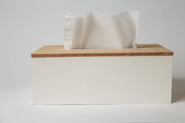 Tahta mendil kutusu, beyaz masa arkaplanlı yüz bezi kabı. Markası yok, reklam boş şablonu.