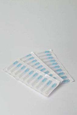 Beyaz arka planda plastik paketin içine şırınga iğneleri yerleştirildi. Enjeksiyon, aşı ya da kozmetoloji için tıbbi ekipman. Boşluğu kopyala.