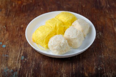 Pismaniye, pamuk helva veya ejderha sakalı vanilyalı ve kavun tadı beyaz tabakta, ahşap arka planda. Türk tatlısı, hafif helva, pamuk helva. Boşluğu kopyala