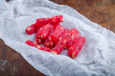 Türk lokumu, beyaz kağıtta fındıklı kırmızı lokum çubukları, ahşap arka plan. Doğu tatlıları, doğu yemekleri. Geleneksel lezzetli tatlı. Uzayı kopyala Üst görünüm
