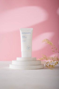 İzmail, Ukrayna. 6 Temmuz 2024. Botanite Aqua uygun güneş esansı SPF 50. Beyaz beton tezgahta Kore kozmetik tüpü, pembe arka plan. Uzayı kopyala Ürün reklam afişi