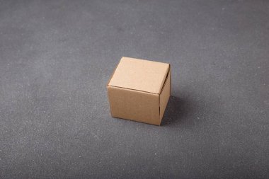Karton kutu, gri arka planda kare kahverengi karton kutu. Markasız, etiketsiz. Uzayı kopyala Paketleme