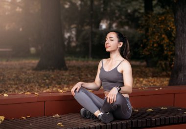 Spor salonundaki kadın yaz parkında yoga egzersizleri yapıyor. Spor Sağlıklı Konsept.