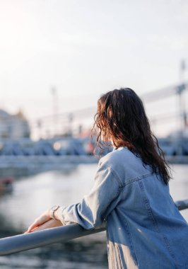 Moda kıyafetleri içinde gülümseyen genç ve güzel bir hippi kadın. Günbatımında Avrupa sokaklarında poz veren seksi tasasız model. Pozitif esmer kadın. Neşeli ve mutlu
