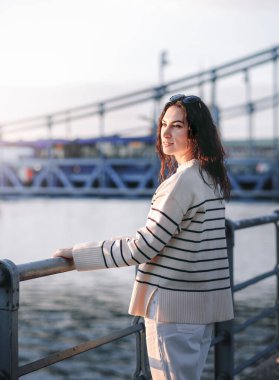 Moda kıyafetleri içinde gülümseyen genç ve güzel bir hippi kadın. Günbatımında Avrupa sokaklarında poz veren seksi tasasız model. Pozitif esmer kadın. Neşeli ve mutlu