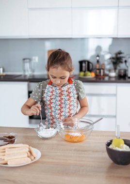 Tiramisu mutfakta işlem yapıyor. Küçük kız kakao ve mascarpone kremalı espresso soslu kadın parmaklarıyla İtalyan çölü yapıyor.)