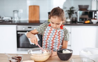 Tiramisu mutfakta işlem yapıyor. Küçük kız kakao ve mascarpone kremalı espresso soslu kadın parmaklarıyla İtalyan çölü yapıyor.)