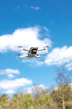 drone flying in silhouette against the blue sky, copter on a blurred background in the sunlight, slow motion