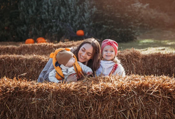 Cheerful family on the farm. Parenting and childhood. Motherhood. Autumn Thanksgiving Day. Outdoor games. Harvesting at farm. Vacation home. Yard decor