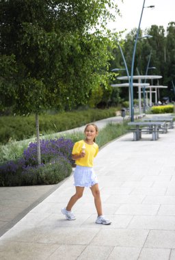 Sevimli gülen küçük kız sıcak bir günde dondurma yiyor. Waffle külahında dondurma. Yazın mutlu ve mutlu bir çocuk..