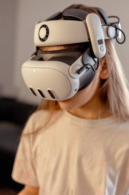 VR gözlüklü kız evde oyun oynuyor. Arttırılmış gerçeklik gözlükleriyle oynamak ve öğrenmek. Teknoloji ve Geliştirme