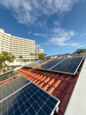 Güneşli bir sahil kasabasındaki bir evin çatısına güneş panelleri monte edilmiş. Alternatif enerji