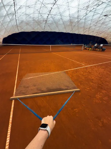 Maçtan sonra tenis kortunu temizlemek. Tenis maçından sonra izleri sürüklemek ve düzleştirmek