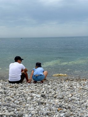 Baba ve kızı deniz kıyısında iletişim kuruyor ve birlikte vakit geçiriyorlar.