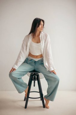 Stüdyodaki genç bayan düşünceli ve neşeli bir ruh hali içinde. Kadın karakteri.