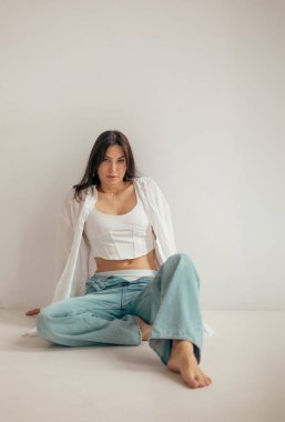 Stüdyodaki genç bayan düşünceli ve neşeli bir ruh hali içinde. Kadın karakteri.