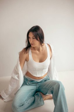 Stüdyodaki genç bayan düşünceli ve neşeli bir ruh hali içinde. Kadın karakteri.