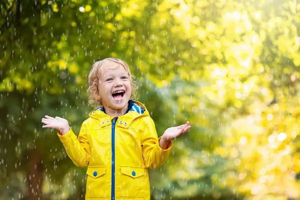 Kinder Spielen Herbstregen Kind Spielt Regnerischen Tagen Freien Kleiner Junge lizenzfreie Stockfotos
