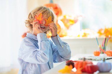 Cadılar Bayramı için aile dekorasyonu evi. Çocuklar için cadılar bayramı sanatı ve el sanatları. Şeker mi şaka mı dekorasyonu mu? Çocuklar evi dekore eder. Cadı kostümlü ve şapkalı çocuklar. Ürkütücü Cadılar Bayramı eğlencesi.
