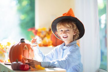 Cadılar Bayramı için aile dekorasyonu evi. Çocuklar için cadılar bayramı sanatı ve el sanatları. Şeker mi şaka mı dekorasyonu mu? Çocuklar evi dekore eder. Cadı kostümlü ve şapkalı çocuklar. Ürkütücü Cadılar Bayramı eğlencesi.