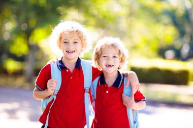 Çocuklar okula geri döner. Yaz tatilinden sonraki yıl yeni bir okula başlıyorum. İlk okul gününde sırt çantası ve kitapları olan kız ve erkek. Dersin başında. Anaokulu ve anaokulu çocukları için eğitim.