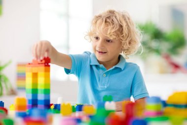 Çocuklar renkli bloklarla oynarlar. Küçük çocuk evde ya da kreşte kule inşa ediyor. Küçük çocuk için eğitici bir oyuncak. Bebek ya da bebek için yaratıcı bir oyun. Anaokulu oyun odasında karışıklık..