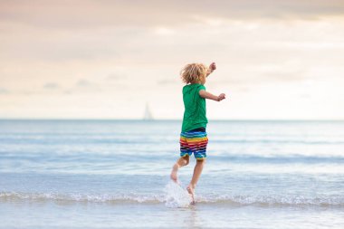 Tropik plajda oynayan bir çocuk. Deniz kıyısındaki küçük erkek bebek. Aile yaz tatili. Çocuklar su ve kum oyuncaklarıyla oynuyor. Okyanus ve ada eğlencesi. Asya 'da küçük çocuklarla seyahat et..